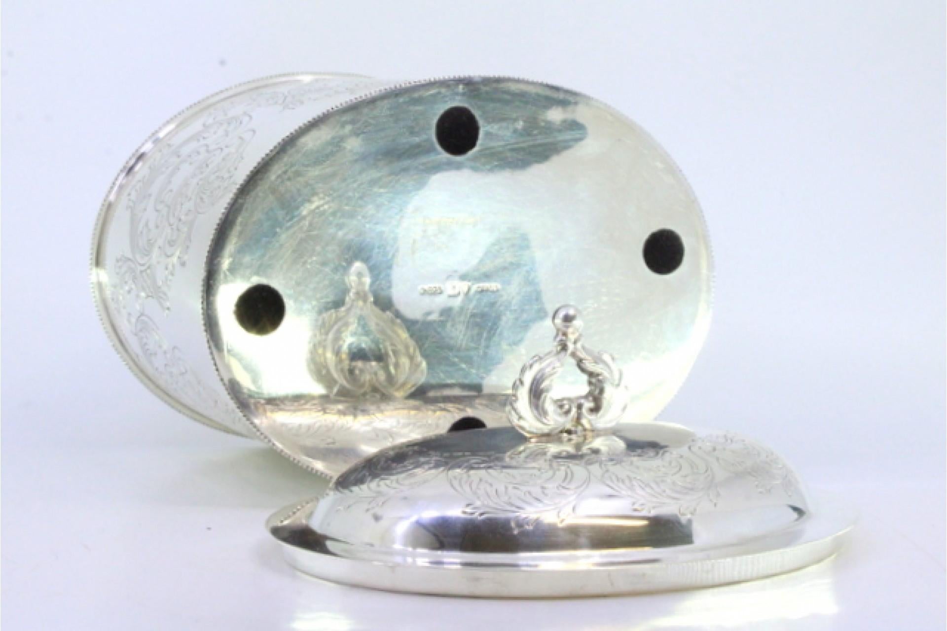 Descrizione: Scatola da tè in argento con motivi vegetali incisi, fregi perlati sul bordo e pomello intagliato sul coperchio. Metallo: Argento. Origine: Portoghese. Marchio: aquila ad ali aperte. Peso: 694,01 grammi. Dimensioni: 15,7cmx16cm.