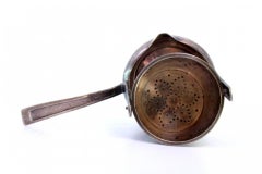 Silver tea strainer w/ tilting cup-shaped container & handle w/ raised grooves