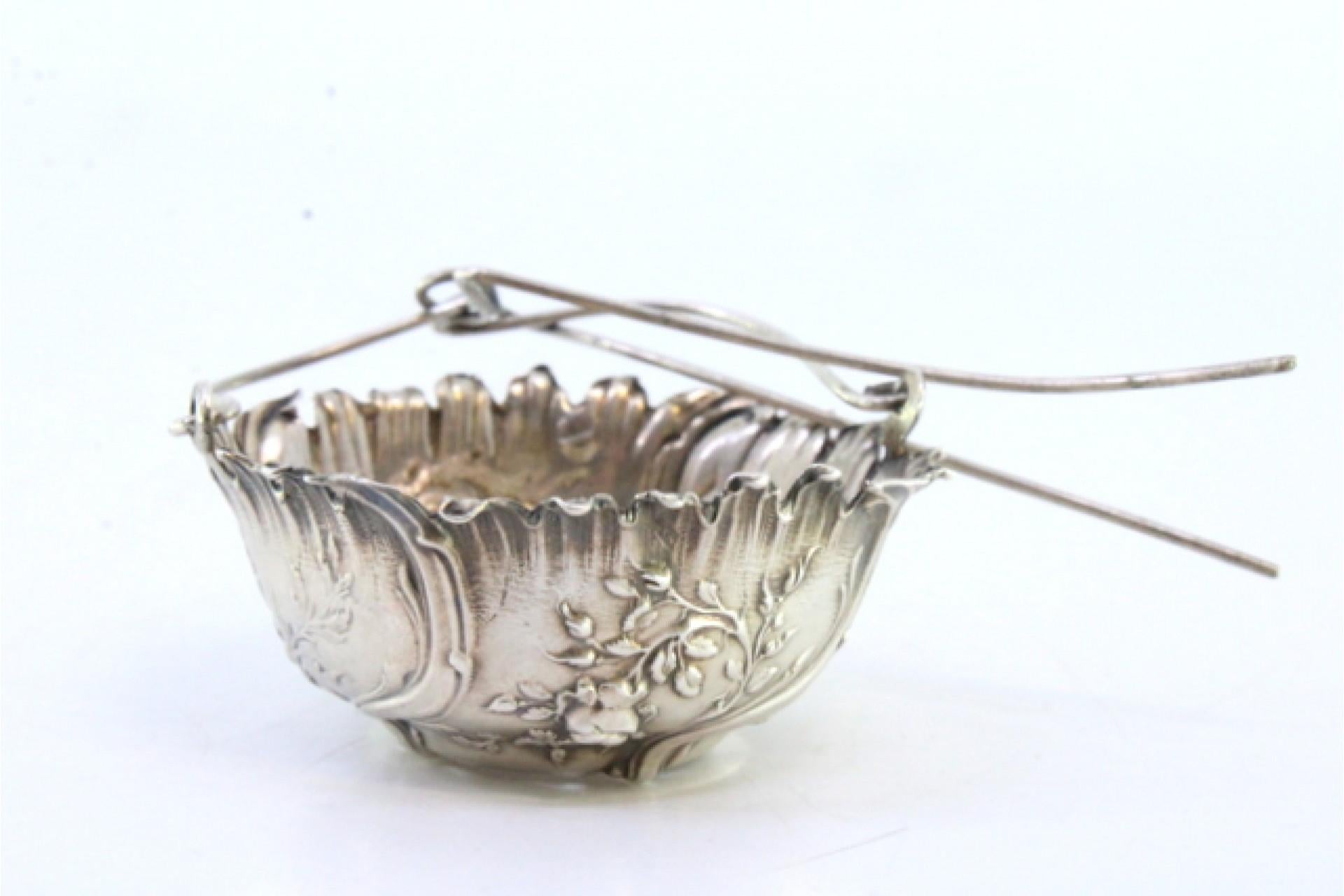 Europeo Silver tea strainer with raised plant motifs and hinged handle in vendita