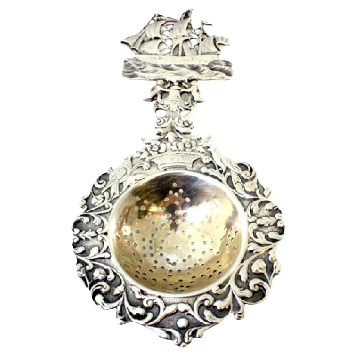 Silbernes Teesieb mit Reliefs und Applikationen, Karavellenausschnitt am Griff