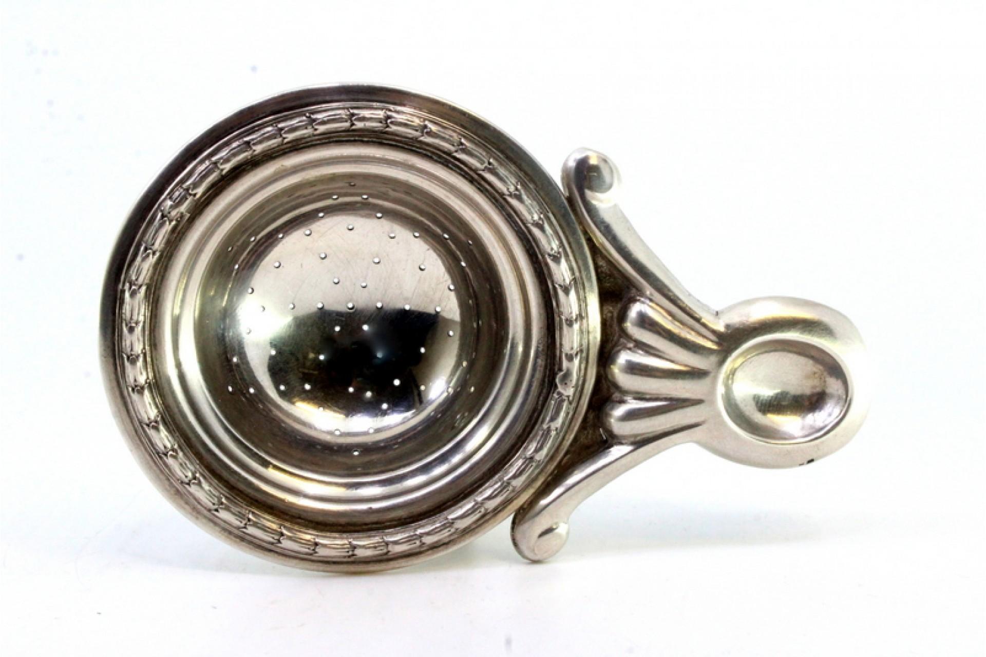 Description : Passoire à thé en argent avec reliefs et applications. Métal : Argent. Origine : Portugais. Marque : Eagle Head. Poids : 72,21 grammes. Dimensions : 13,5 cm x 8,7 cm : 13,5cmx8,7cm. Contenu : 833/1000. Marque d'essai : Oui, entre 1938