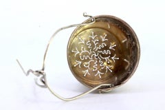 Silver tea strainer with reliefs and hinged handle