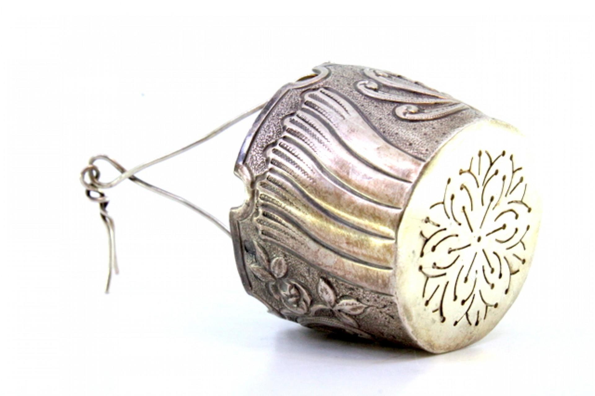 Argento Silver tea strainer with reliefs, cut-out edge and hinged handle in vendita