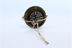 Silver tea strainer with rim and hinged handle