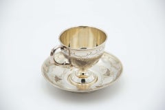 Silver teacup and saucer with floral motifs