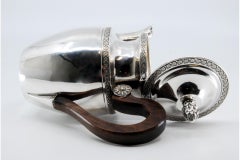 Silver teapot w/ engraved plant motifs, wooden handle & knob on the hinged lid