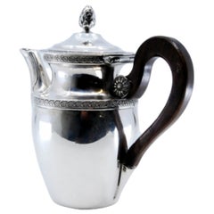 Silver teapot w/ engraved plant motifs, wooden handle
knob on the hinged lid