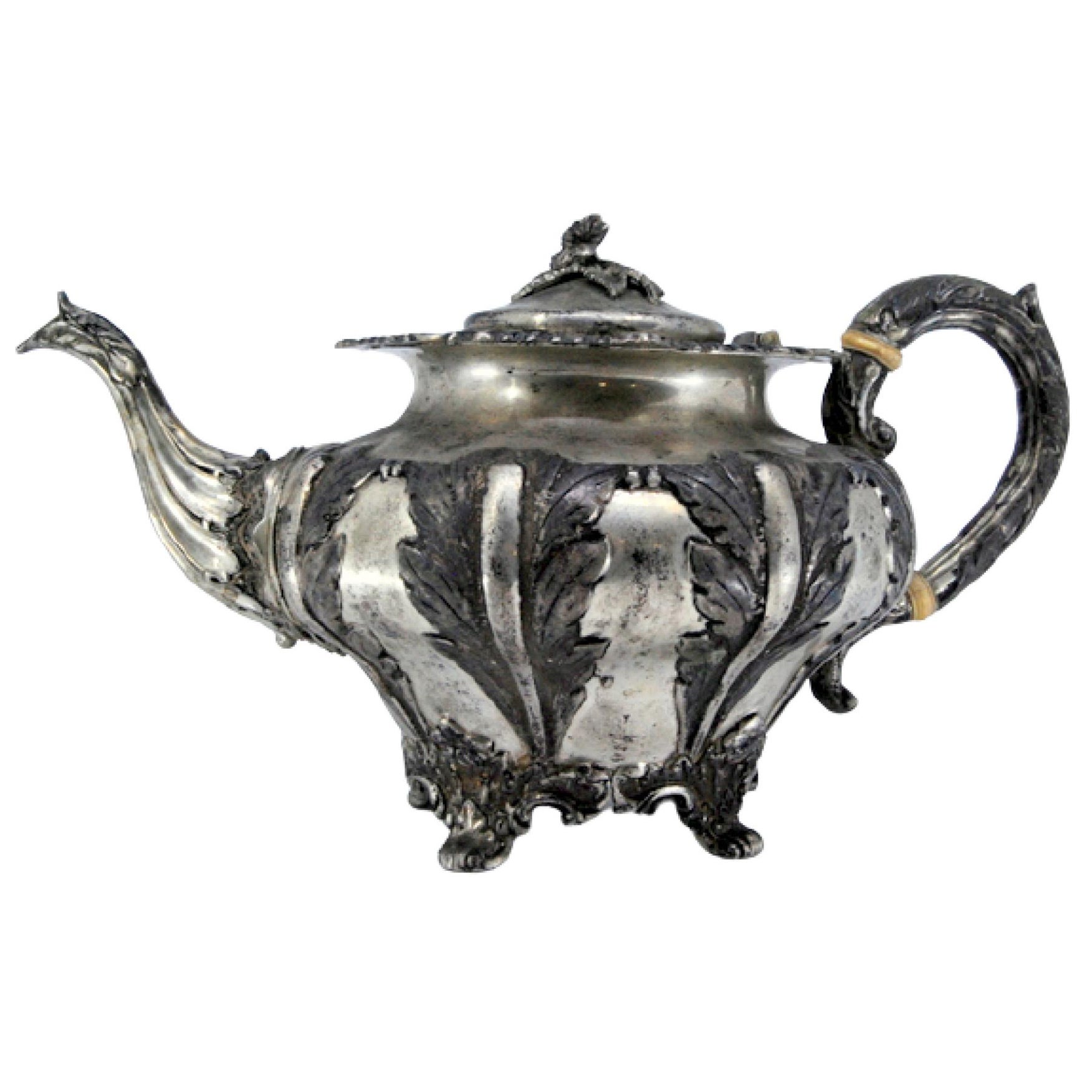 Silver teapot with applied details, reliefs and four-footed base