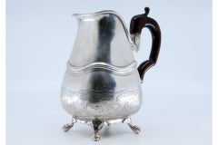 Silver teapot with floral engravings, friezes and chestnut handle on feet