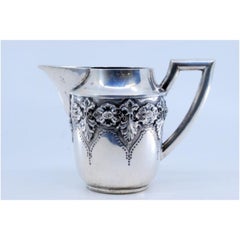 Silver teapot with raised floral motifs and straight handle