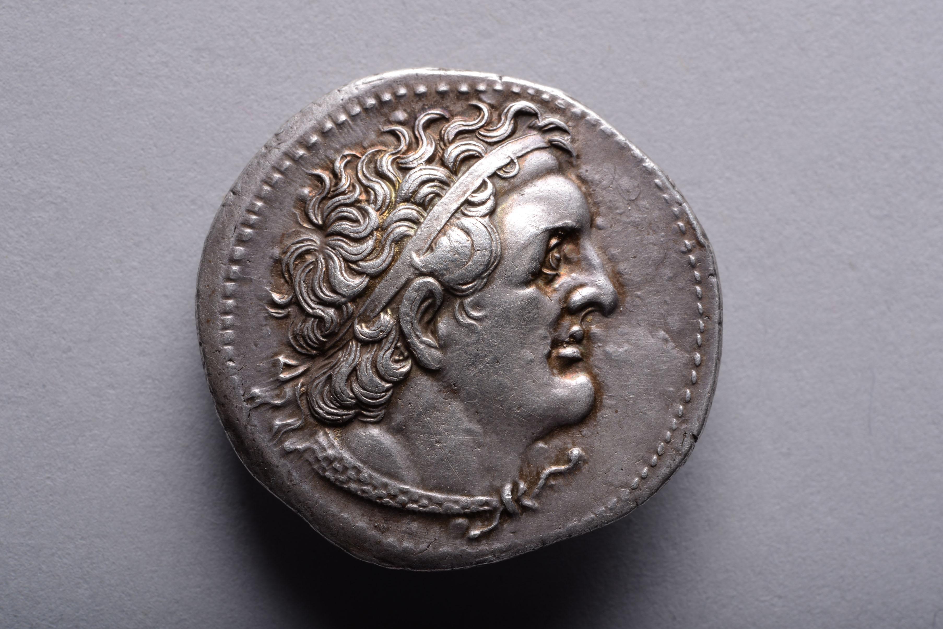 Silver tetradrachm issued by Ptolemy I Soter (Saviour), circa 300-285 BC, Alexandria mint.

The obverse with the head of Ptolemy, in bold Hellenistic style; the wild curls of his hair bursting out from under a royal diadem. Signed, behind the ear,