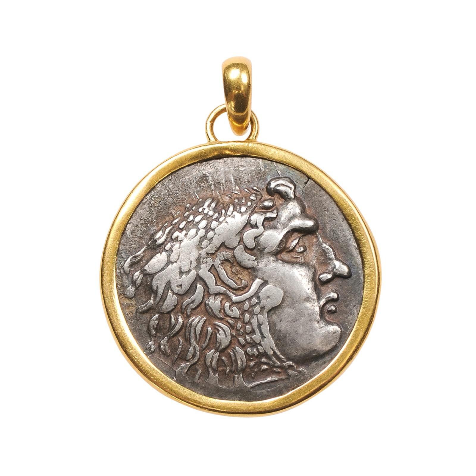 Tetradramma d'argento [moneta] con il profilo del giovane Alexander il Grande rifinito con oro 22k. Questo profilo del viso altamente dettagliato mostra anche una testa piena di capelli lucenti e un naso pronunciato e regale. Sul rovescio di questa