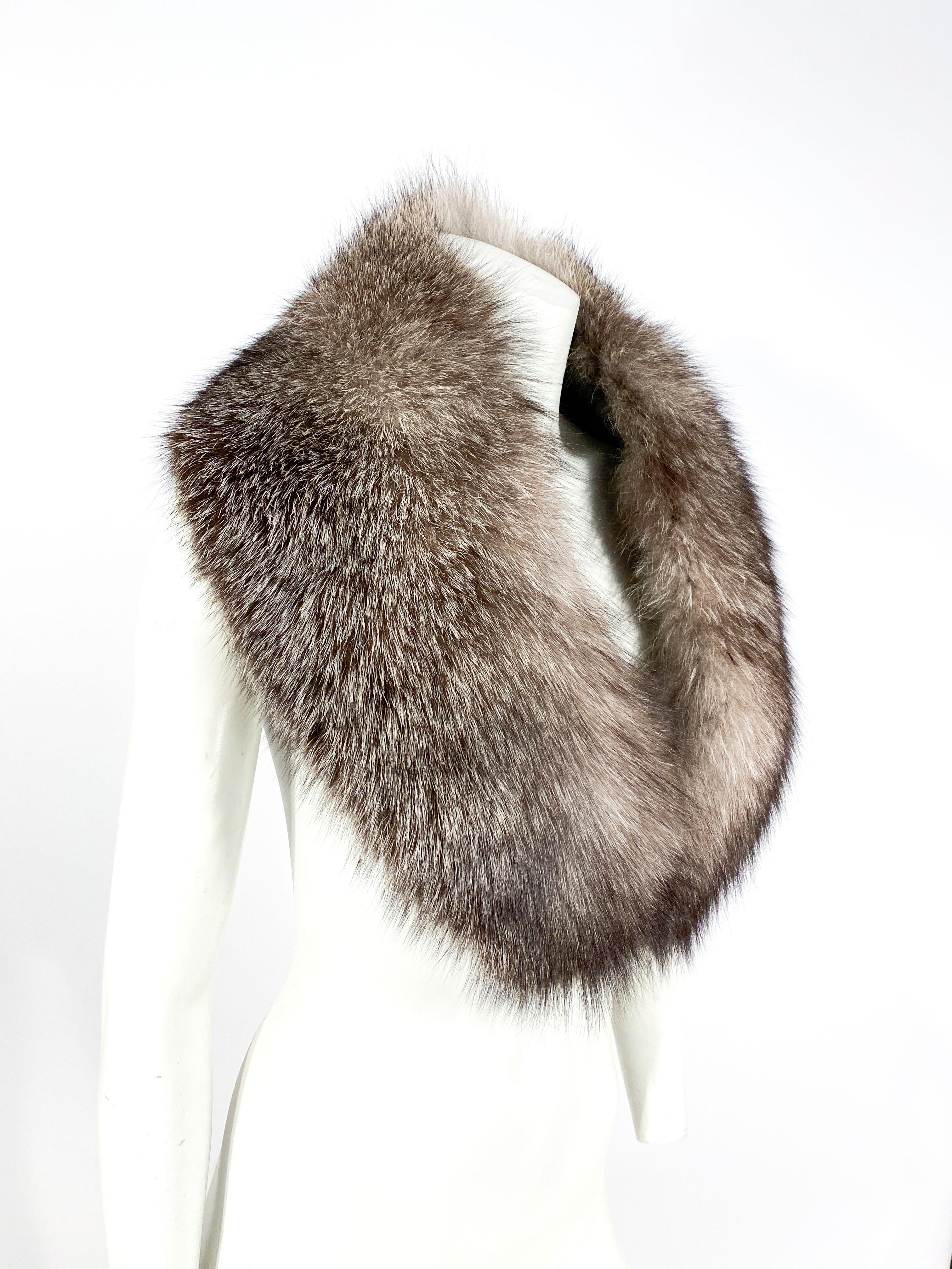 Silver tipped full fox that can be worn as a stole or an enlarged collar. The fur is very dense and very soft with a traditional fur hook closure. The fur is entirely lined with a silver floral pattern textile. 