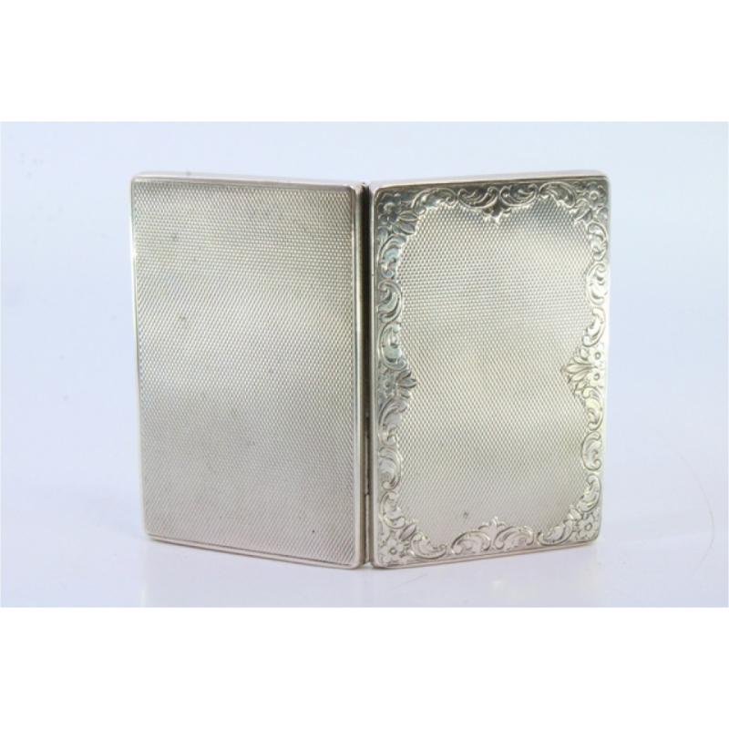 Description: Silver tobacco box with guilloche floral motifs, gold interior and hinged lid. Metal: Silver. Origin: German. Brand: Unknown. Weight: 59.37 grams. Dimensions: 8cmx5cm. Content: 835/1000. Assay Mark: Yes. Additional information: Good