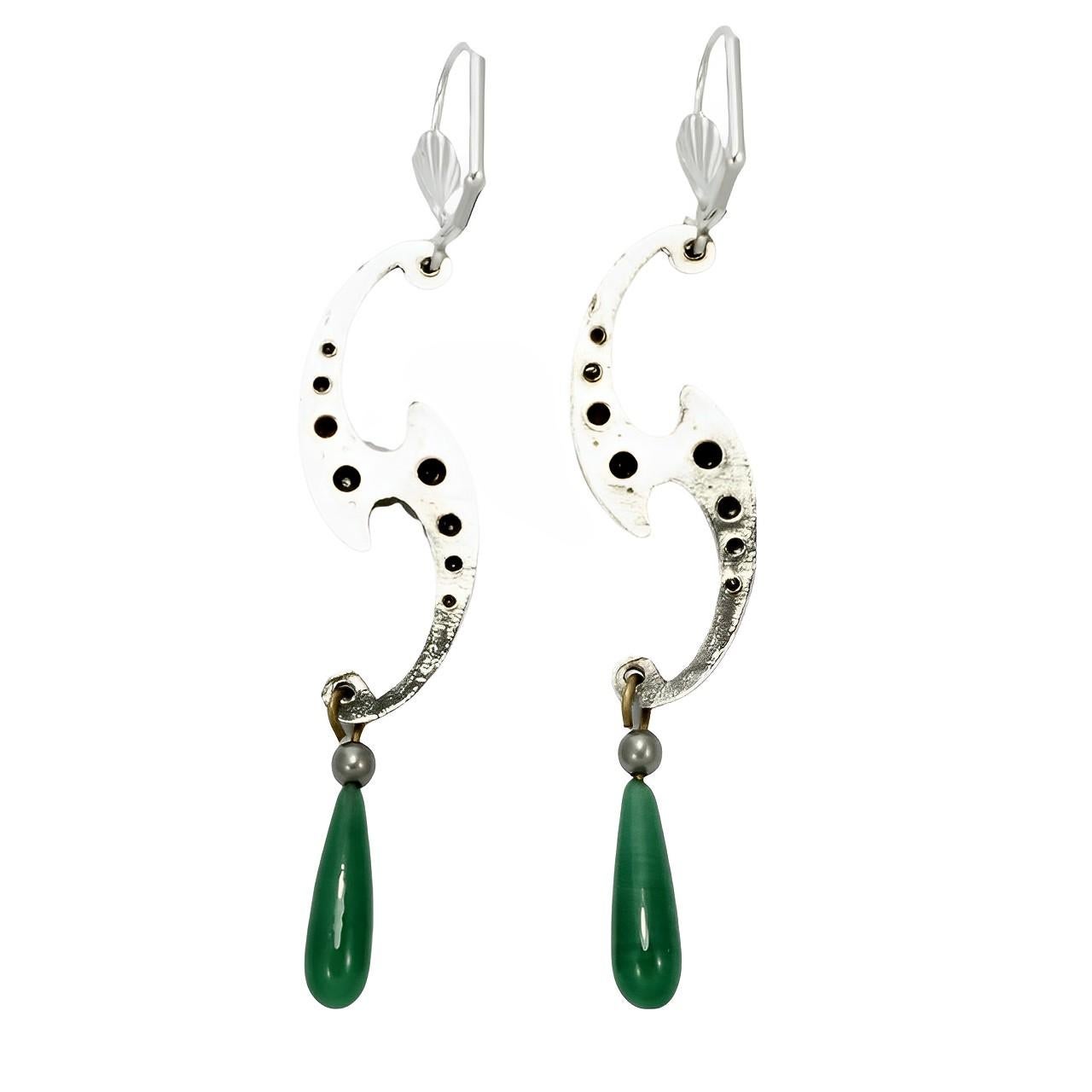 Eleganti orecchini in argento con strass incastonati a mano e gocce di vetro verde. Misura 5,7 cm di lunghezza, senza contare i dorsi a leva.

Si tratta di un elegante paio di orecchini realizzati con componenti d'epoca e con nuovi supporti a leva.