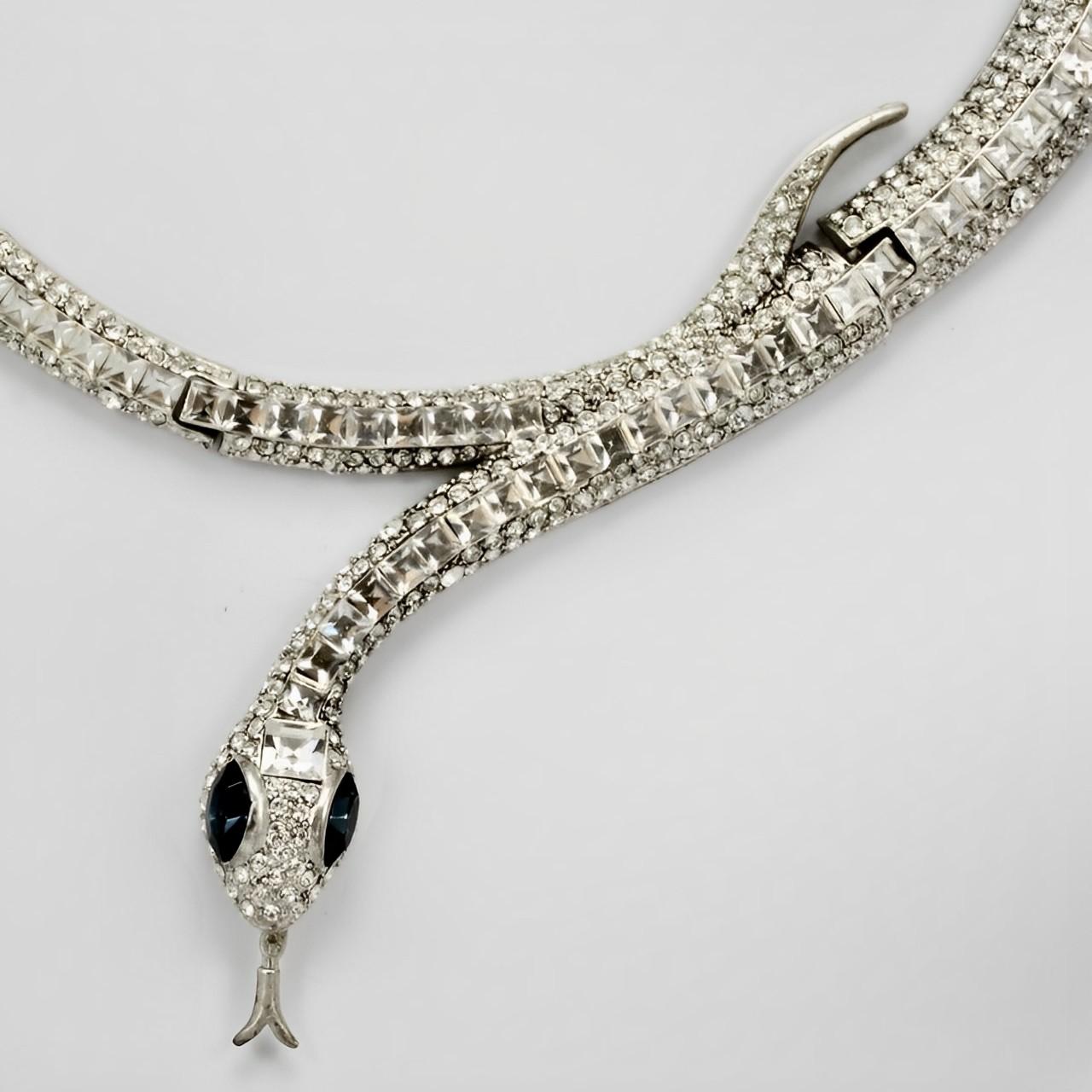 Wonderful silver tone snake collar with black enamel detail, and set with square and round clear rhinestones at the front. The snake has mid blue rhinestone eyes, and a trembler tongue which is held on a spring. The necklace is curved to sit around