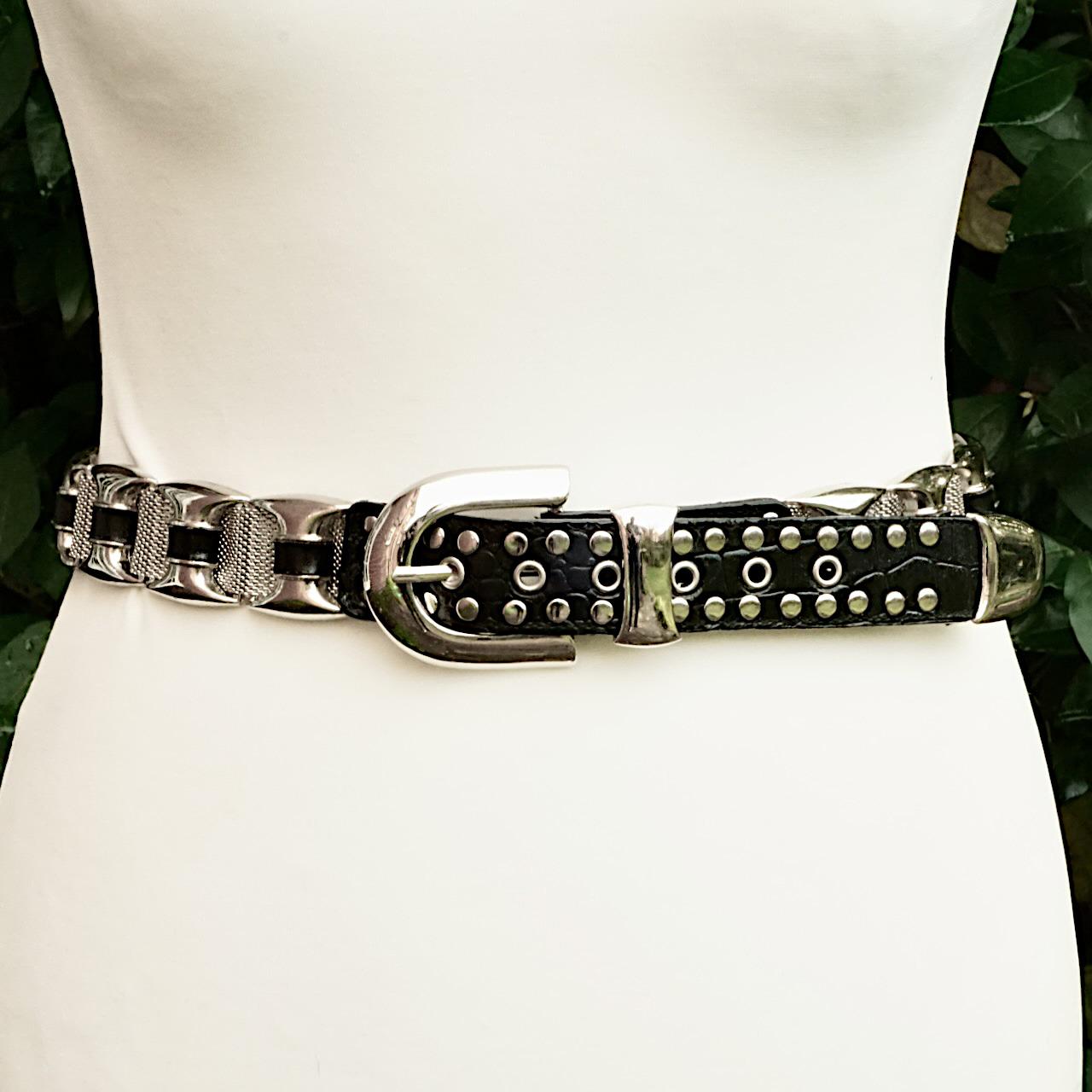 Wonderful silver tone and black leather belt, featuring decorative mesh links and stud detail. The belt is adjustable, from a wearable length of 95.5 cm / 37.6 inches to 85.5 cm /  33.6 inches, and the width is 3.35 cm / 1.3 inches. The buckle