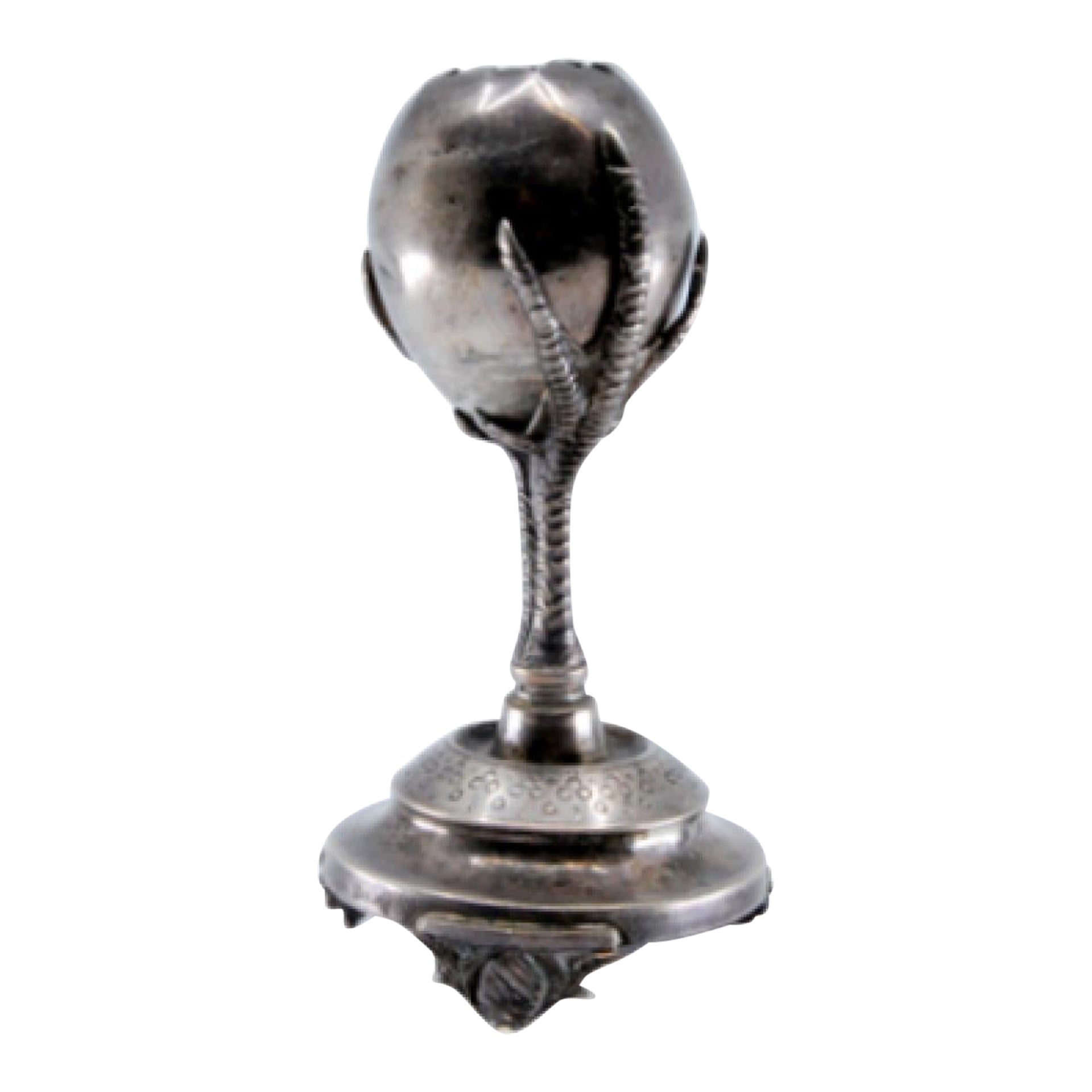 Silver toothpick holder in the shape of a broken egg and fixed on two claws