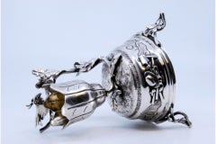 Silver toothpick holder in the shape of a flower and a bird perched on a branch