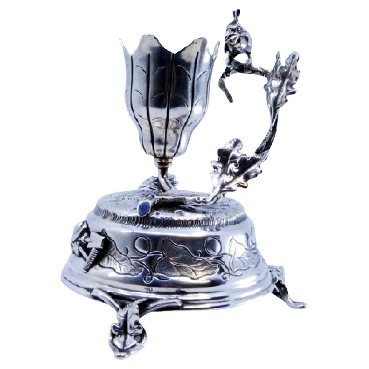 Silver toothpick holder in the shape of a flower and a bird perched on a branch