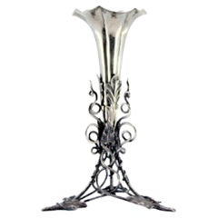 Silver toothpick holder w/ flower-shaped chalice
resting on a flowerpot plant