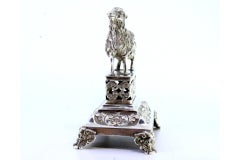 Silver toothpick holder w/ goat on a plinth cut w/ reliefs & resting on 4 feet