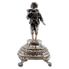 Silver toothpick holder with boy carrying basket on raised base