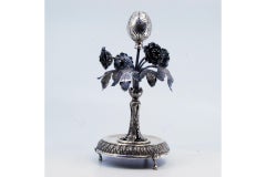 Silver toothpick holder with flowers, leaves, palms and resting on a raised base
