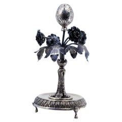 Silver toothpick holder with flowers, leaves, palms and resting on a raised base