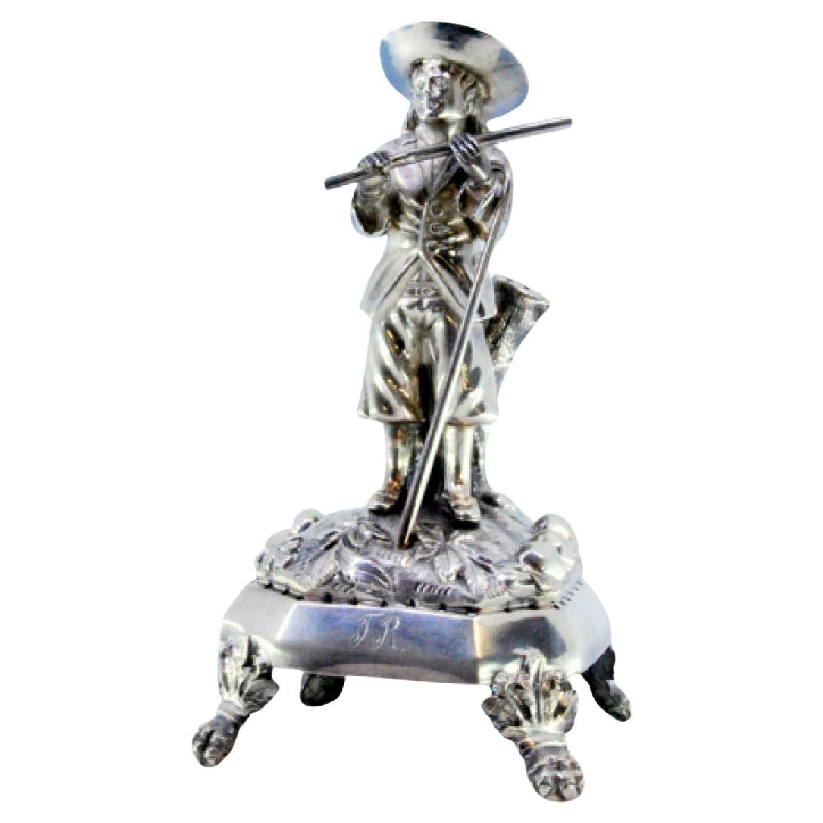 Palillero de plata con flautista de pie sobre un zócalo