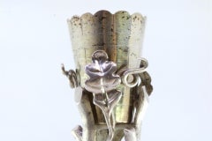Silver toothpick holder with golden chalice surrounded by vines and tree trunks