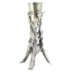 Silver toothpick holder with golden chalice surrounded by vines and tree trunks