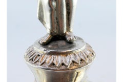 Silver toothpick holder with lady holding cup on raised base with three feet