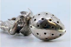 Silver toothpick holder with male figure holding strawberry on engraved base