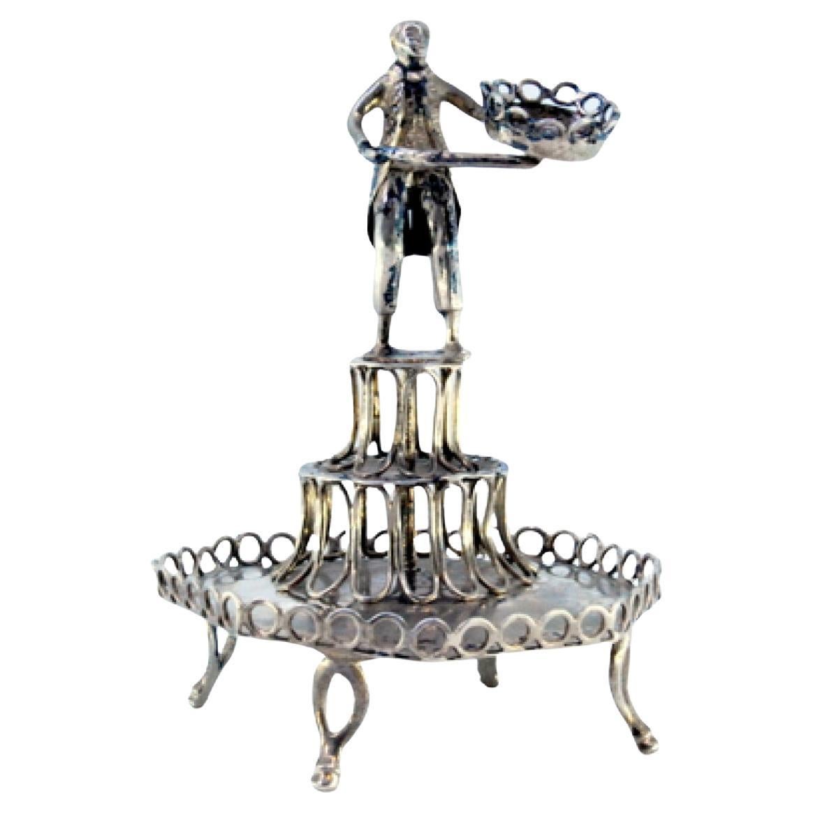 Silver toothpick holder with male figure standing on a pedestal