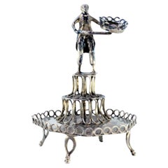Silver toothpick holder with male figure standing on a pedestal