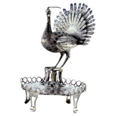 Silver toothpick holder with peacock perched on a base with a wire rack