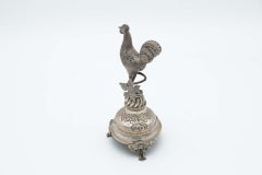 Silver toothpick holder with rooster perched on a flower bed