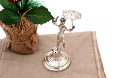 Silver toothpick holder with saleswoman on pedestal