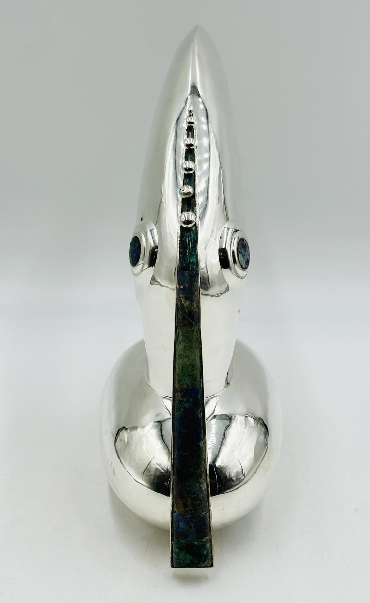 Vintage silver plated toucan pitcher with Lapis Lazuli and Azurite inlay designed and manufactured in Taxco Mexico by Los Castillo.
 
More than a utilitarian piece, this pitcher is more of a sculpture, the workmanship and attention to detail is