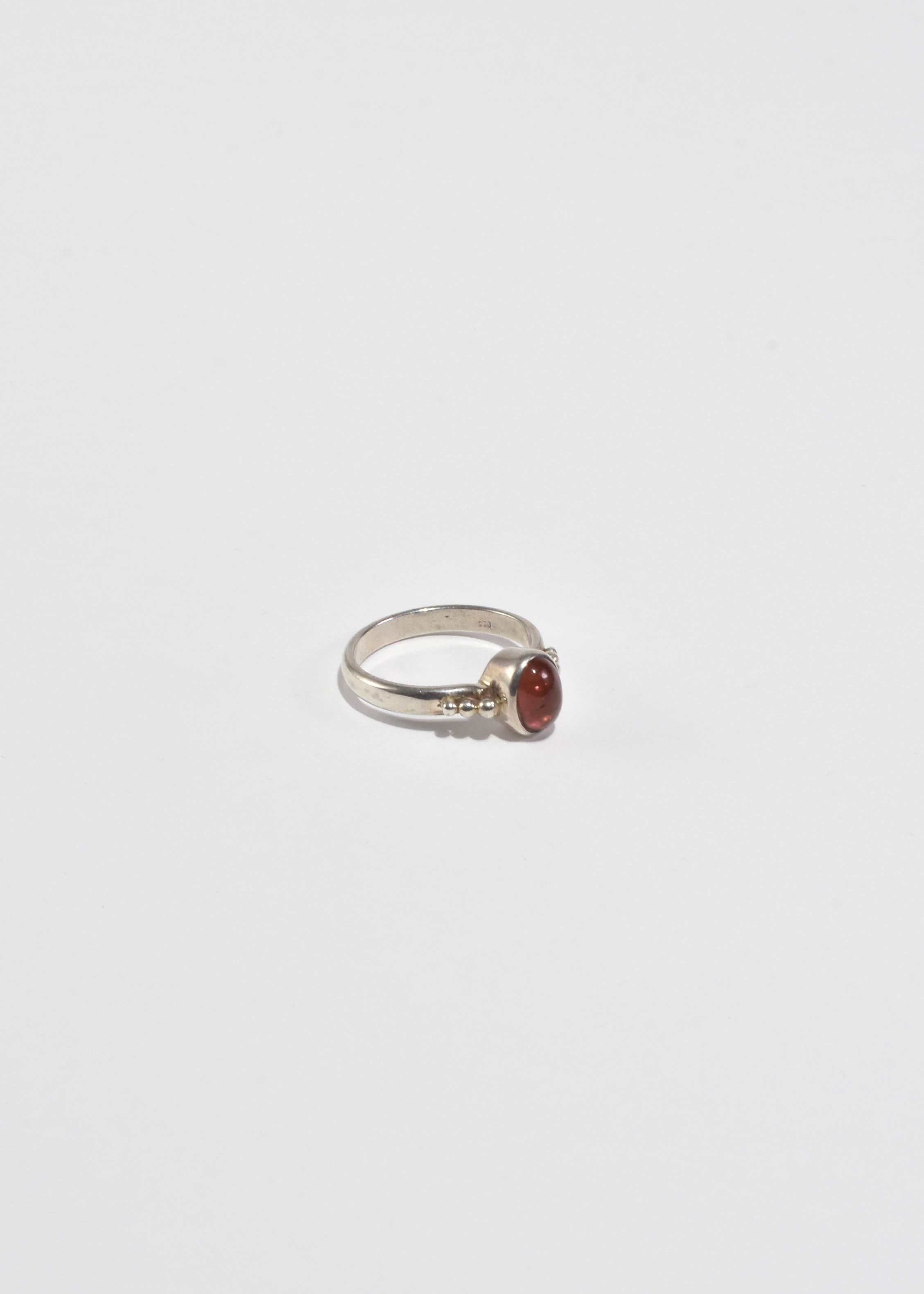 Vintage silver ring with dot detail and oval pink tourmaline cabochon. Stamped 925.

Material: Sterling silver, tourmaline.