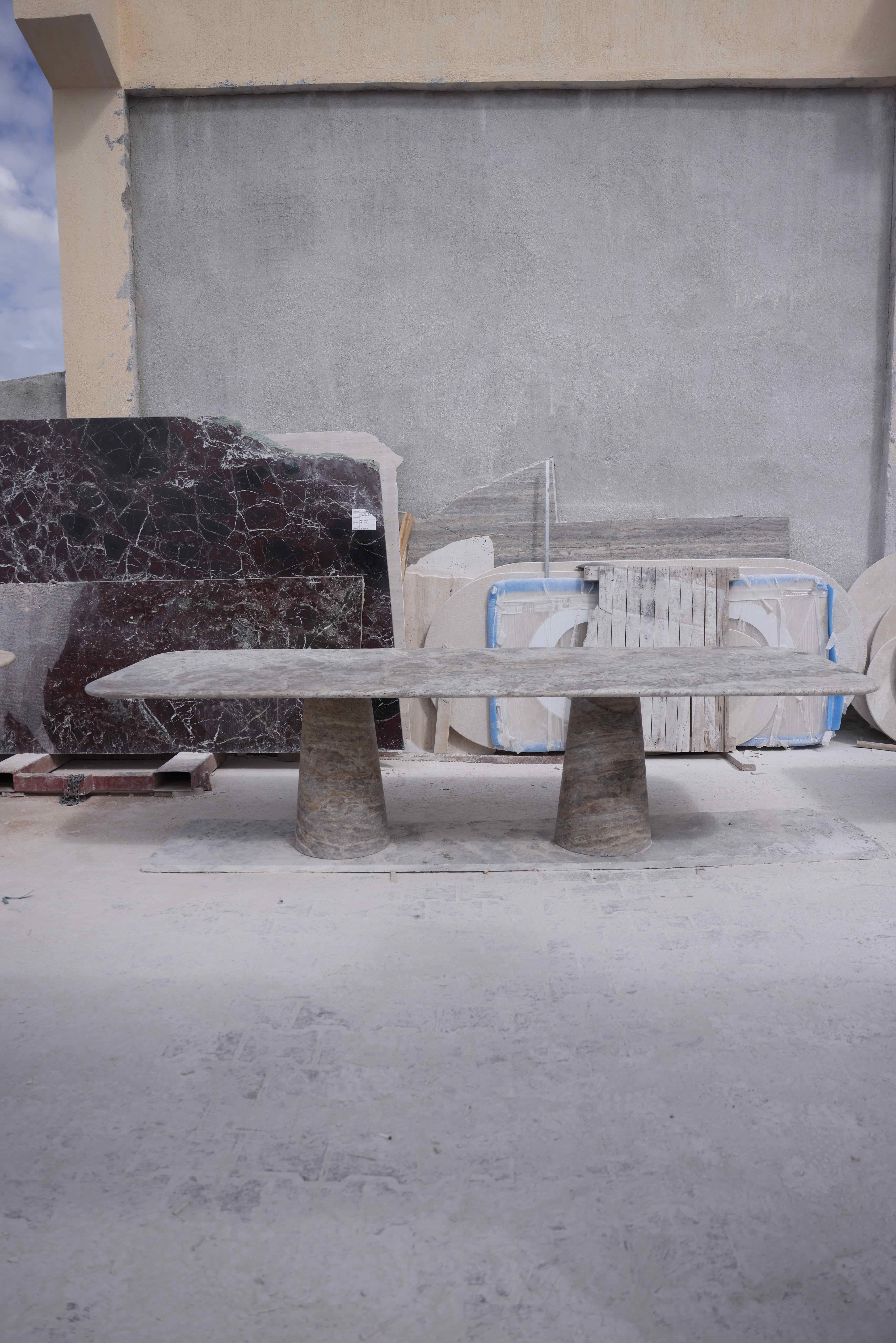 This Large minimalist table is made from solid, Silver travertine, featuring a rectangle table top that balances perfectly and securely on two pedestal legs. 

Drawing inspiration from the vintage pieces of Angelo Mangiarotti, the column legs give