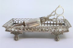 Silver tray and scissors with wire rack resting on four claw feet