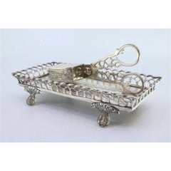 Silver tray and scissors with wire rack, resting on four claw feet