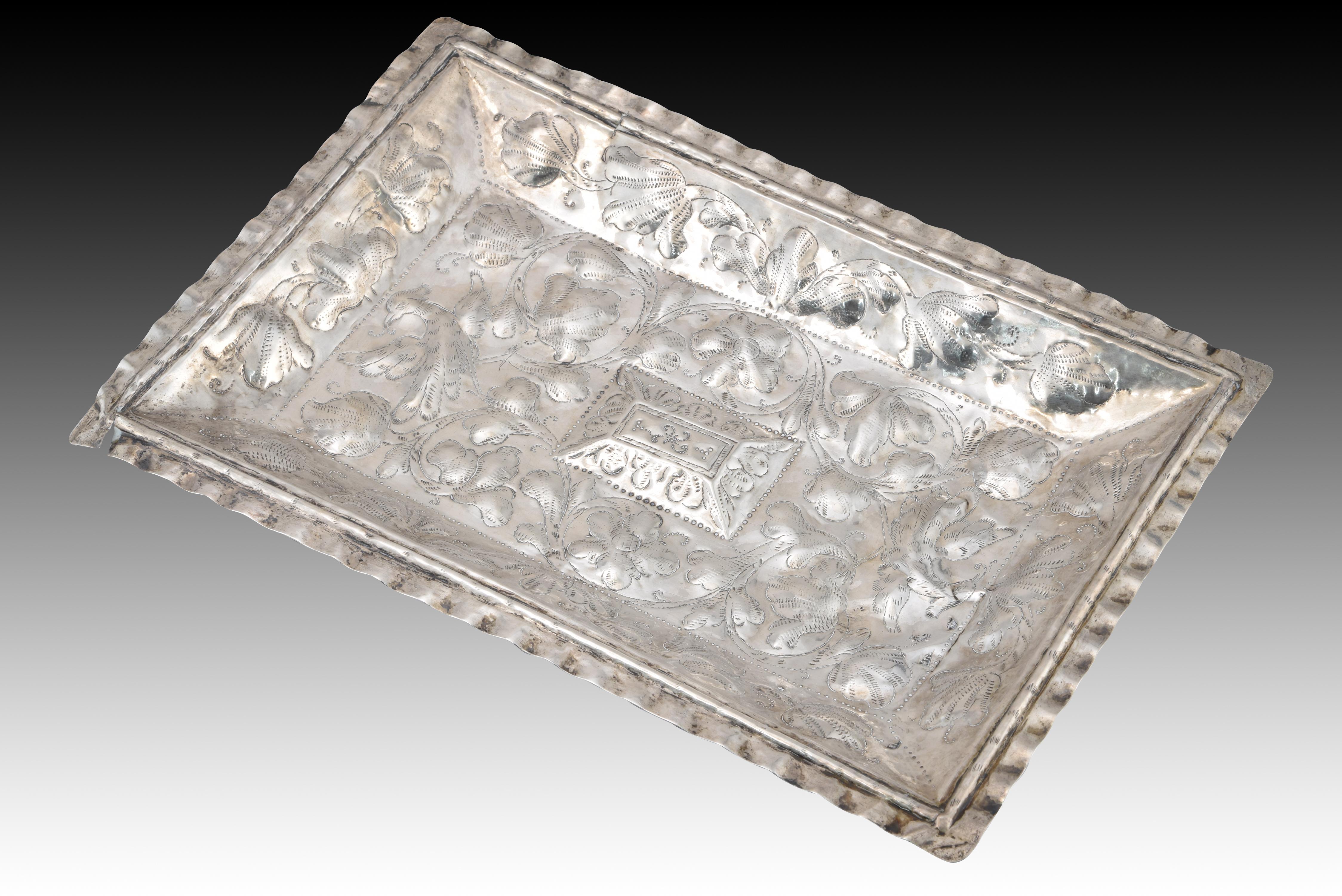 Silver tray in its color. Possibly Spain, 20th century. 
Has damage. 
Silver tray in its color, rectangular in shape with wavy edges and center and bottom decorated with an embossed composition on a vegetable theme, arranged around a central