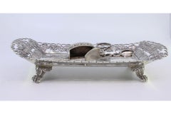 Silver tray & scissors w/ chiseled grate & resting on 4 raised claw-shaped feet
