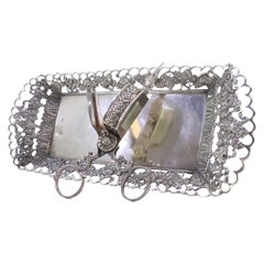 Silver tray 
scissors w/ chiseled grate 
resting on 4 raised claw-shaped feet