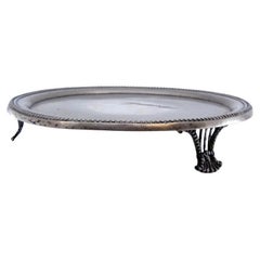 Silver tray w/ a smooth bottom, pearly frieze 
resting on three cut-out feet