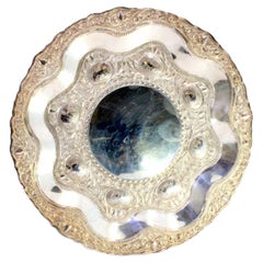Silver tray w/ floral 
animal motifs in relief 
a smooth card in the center