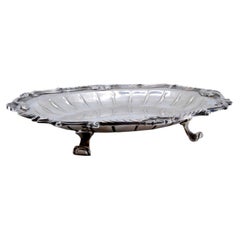 Silver tray w/ raised base, engravings 
scroll frieze on 4 feet